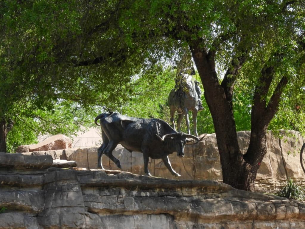 Photo taken of a bull sculpture in a park.