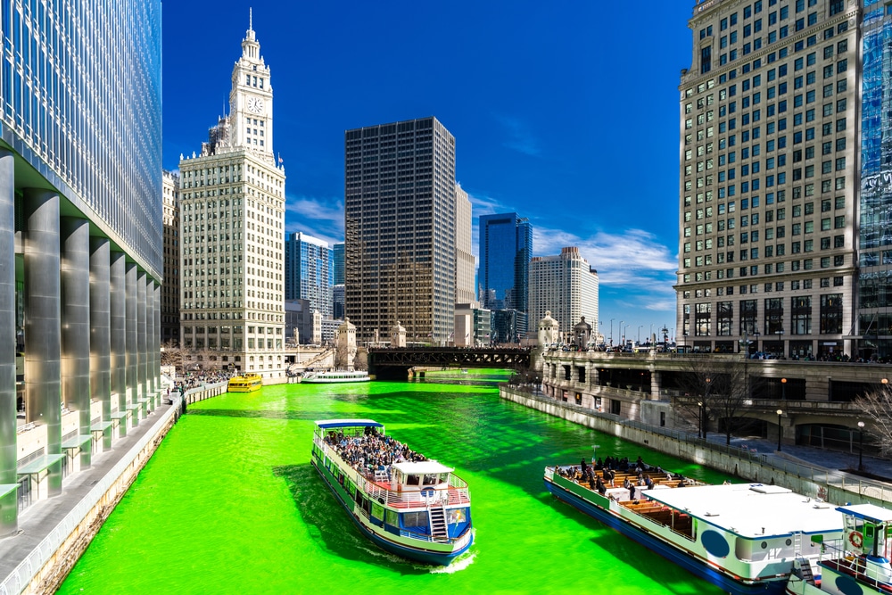 View of Chicago Riverwalk during St. Patrick's, the water is tinted a bright green to celebrate.
