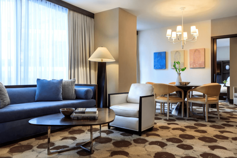 Inside a room at the The Royal Sonesta Chicago River North with a dining table and couch and coffee chair.
