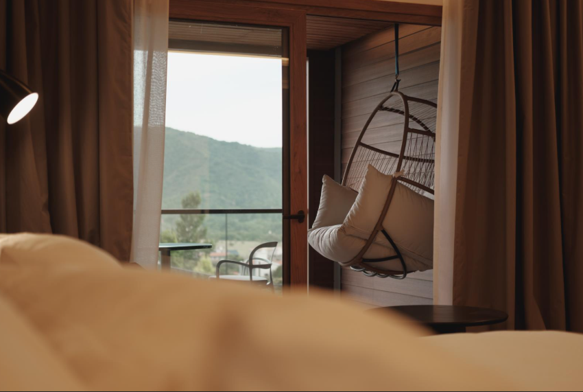 A cozy bedroom featuring a window that offers a scenic view of a majestic mountain landscape.