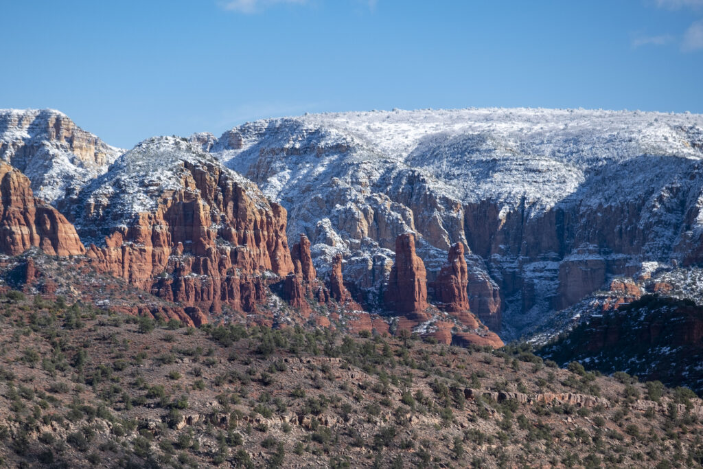 Snow blankets the red rock formations of Sedona, Arizona, creating a striking contrast against the vibrant landscape.