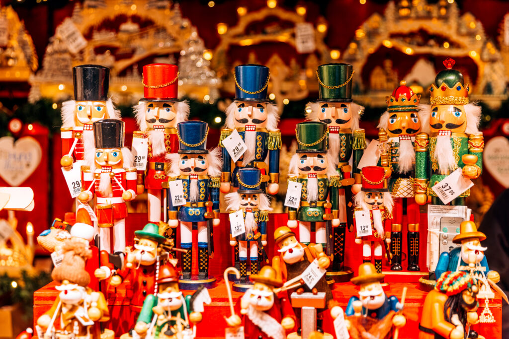A colorful display of nutcrackers arranged at a festive Christmas market, showcasing various designs and sizes.