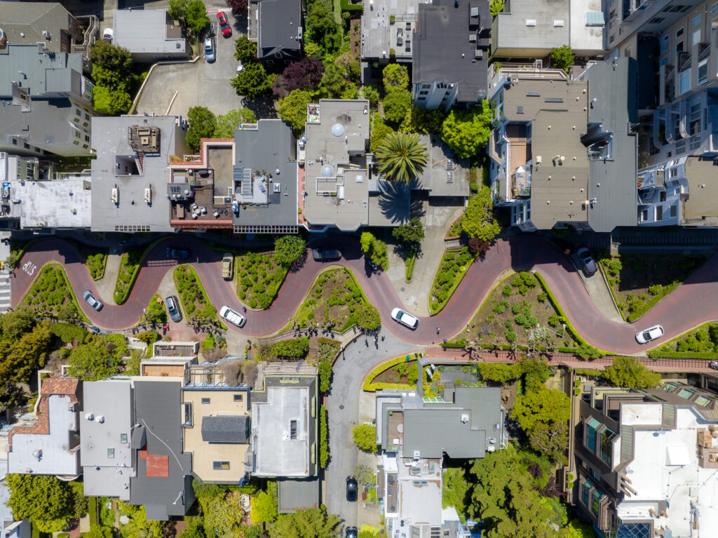 Aerial view of a city street featuring a road and a sidewalk, showcasing urban layout and traffic patterns.