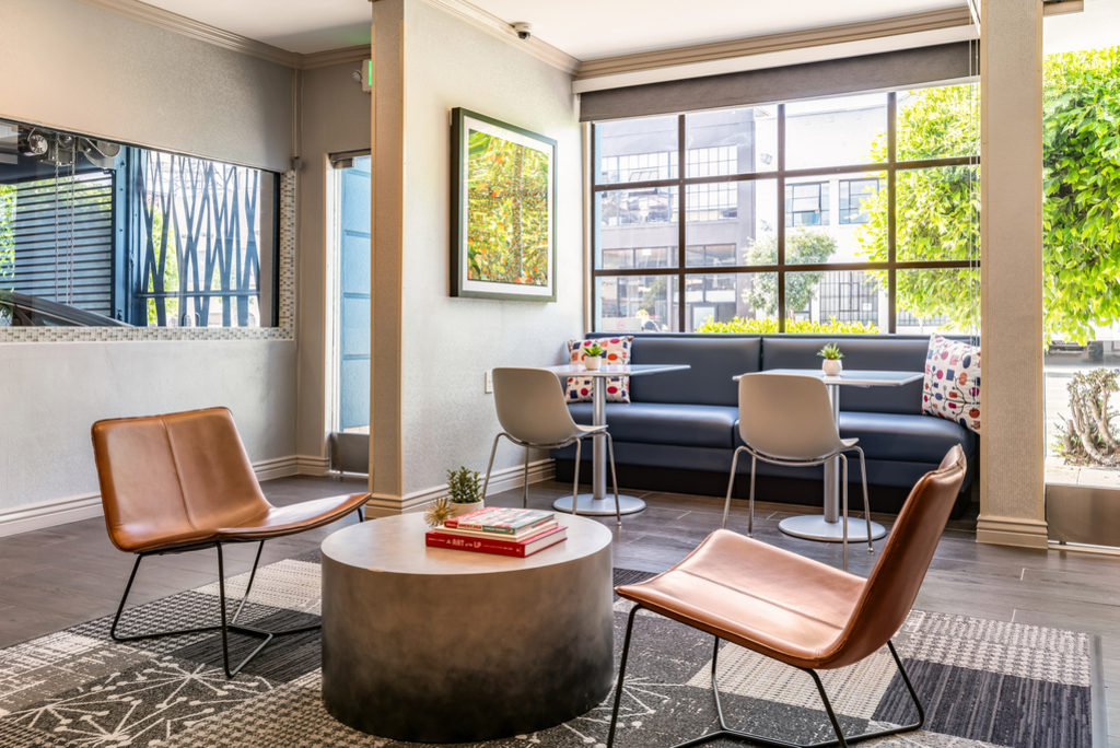 A spacious lobby of a modern apartment building featuring sleek furniture and contemporary decor.