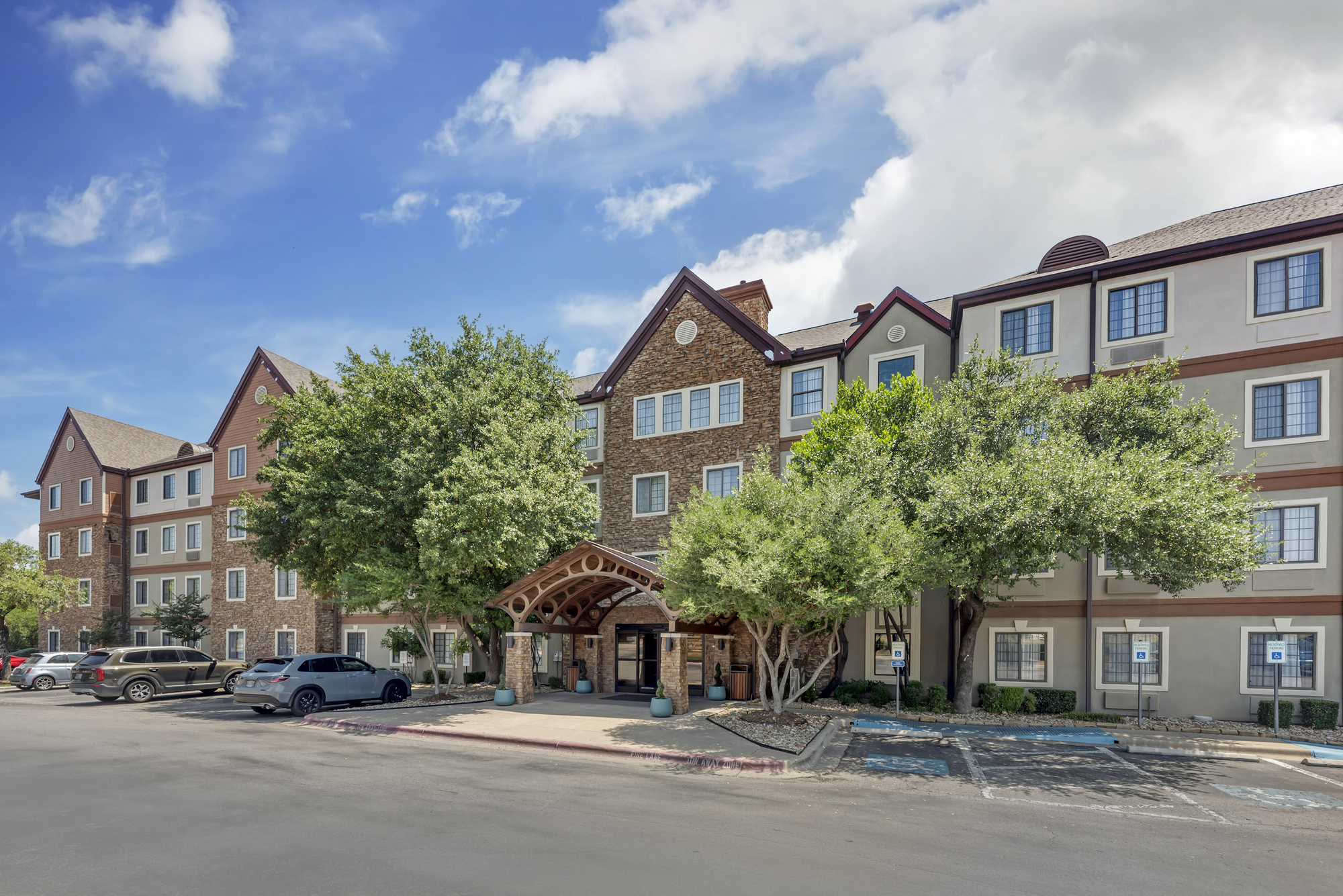 Front entrance of Staybridge Suites in Austin, featuring a welcoming lobby and modern architectural design.