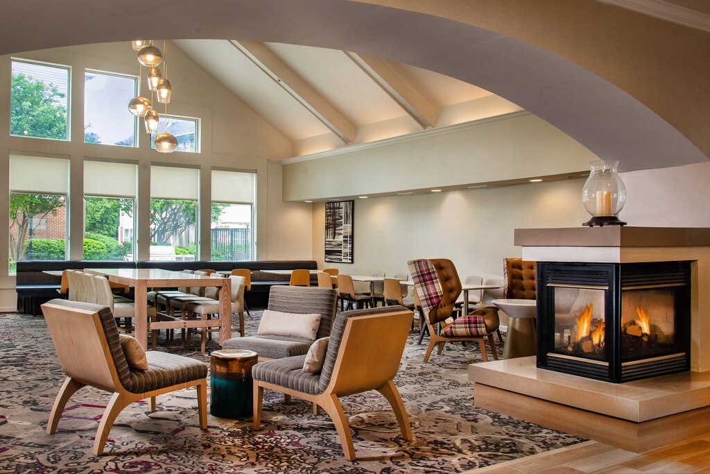 A spacious room featuring a cozy fireplace surrounded by comfortable chairs for relaxation.