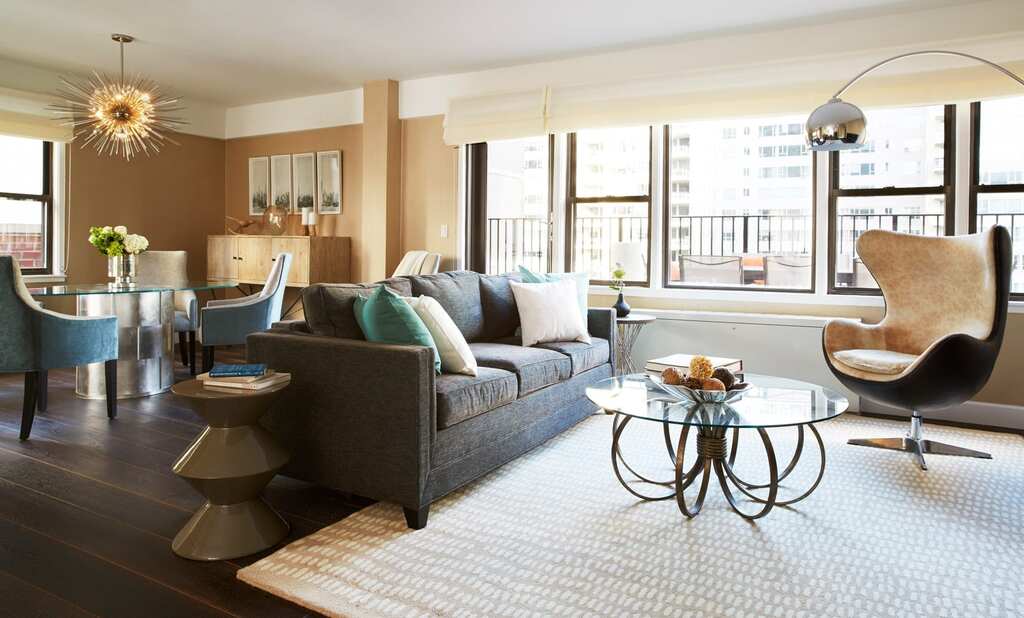 A cozy penthouse living room featuring a couch, a chair, a coffee table, and a side table, all arranged for comfort and relaxation.