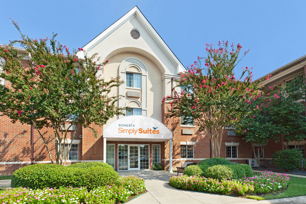 The front entrance of a hotel, featuring well-maintained trees and shrubs that enhance the welcoming atmosphere.
