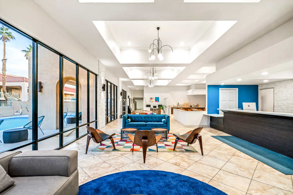 Hotel lobby featuring blue and white walls, with modern furnishings and a welcoming atmosphere.