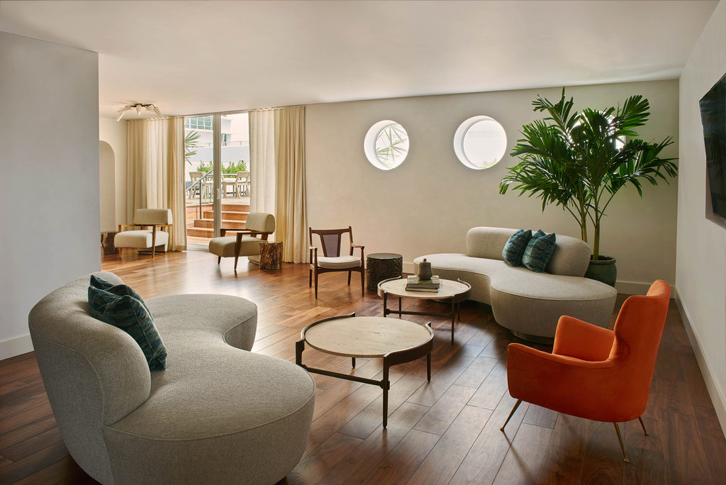 A spacious living room featuring a large window and a comfortable couch, inviting natural light into the space.