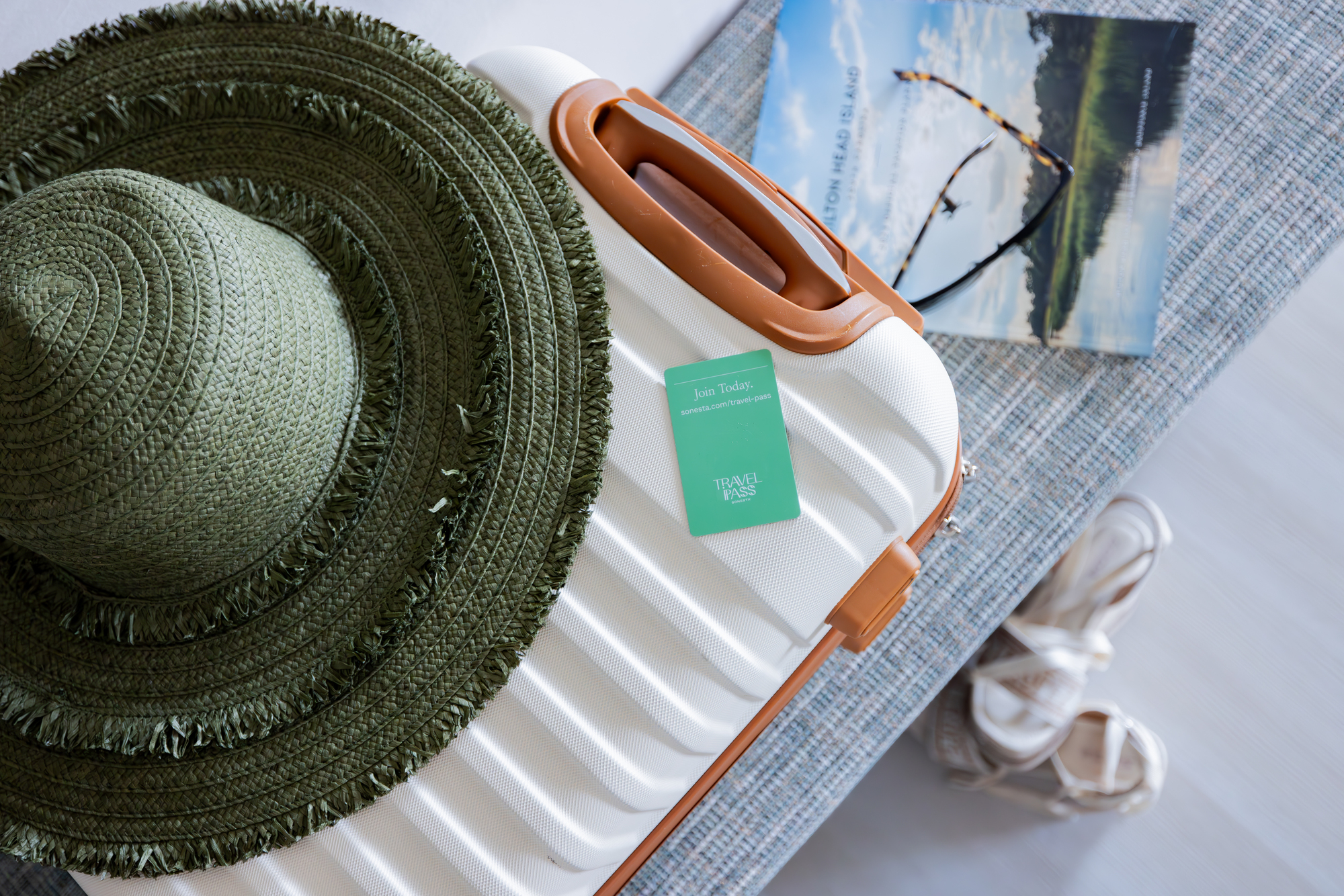 A hat and a suitcase are positioned on a table, evoking a sense of preparation for a journey.