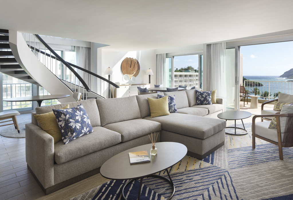 A cozy living room featuring large windows that offer a stunning view of the ocean.