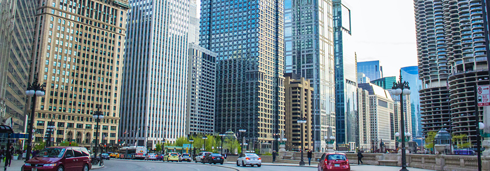 A vibrant urban scene featuring tall buildings and moving cars on a busy city street.