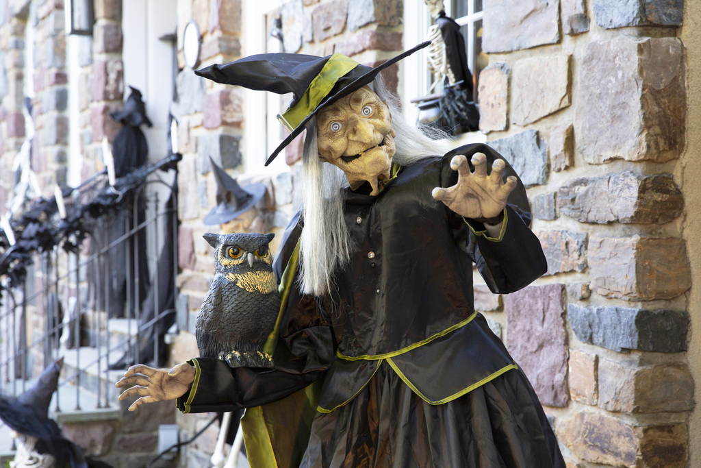 A witch statue with an owl in her arms, featuring elaborate craftsmanship that highlights her enchanting presence.