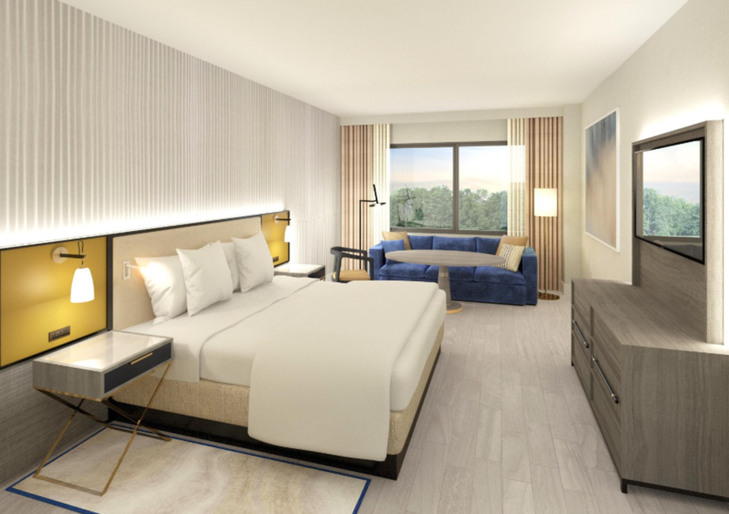 A hotel room rendering featuring a bed, desk, and television, showcasing a modern and inviting interior design.