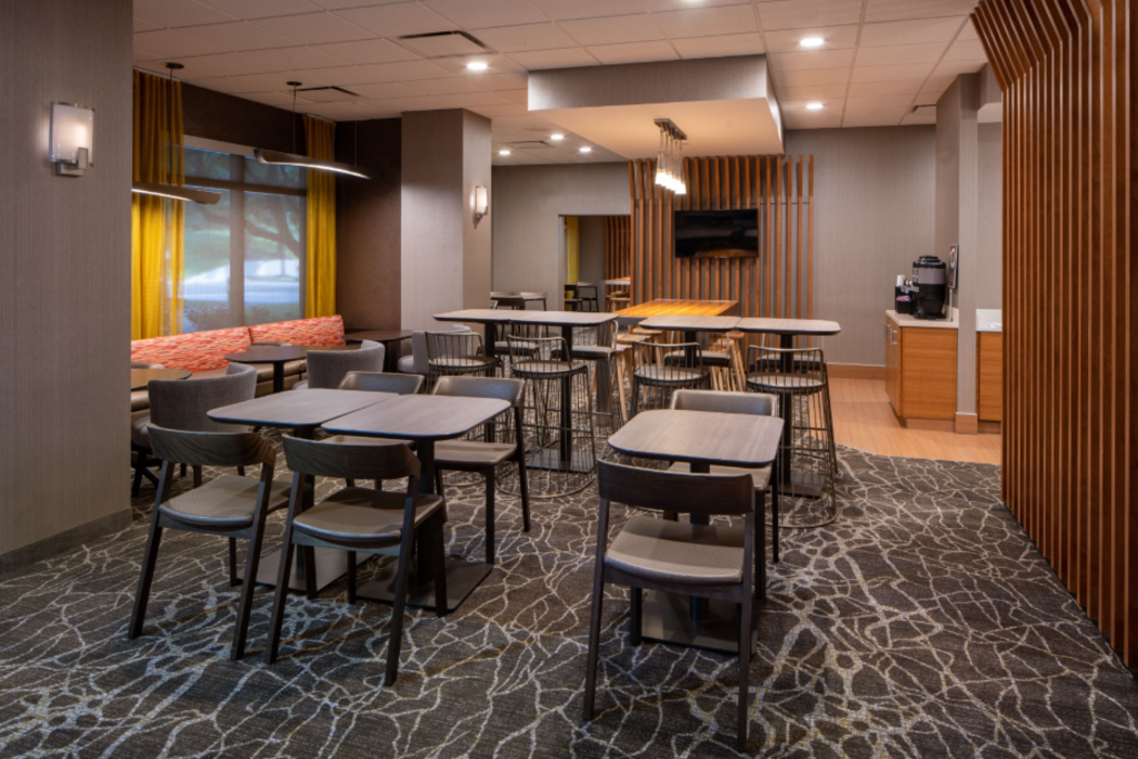 Interior of a contemporary dining area with bright lighting, showcasing organized tables and chairs for guests.
