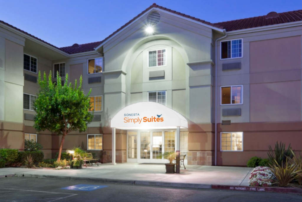 Exterior view of Sonesta Simply Suites, showcasing the building's modern design and welcoming entrance.