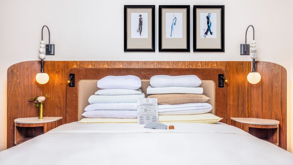 A neatly made bed featuring a white comforter and matching pillows, creating a clean and inviting appearance.