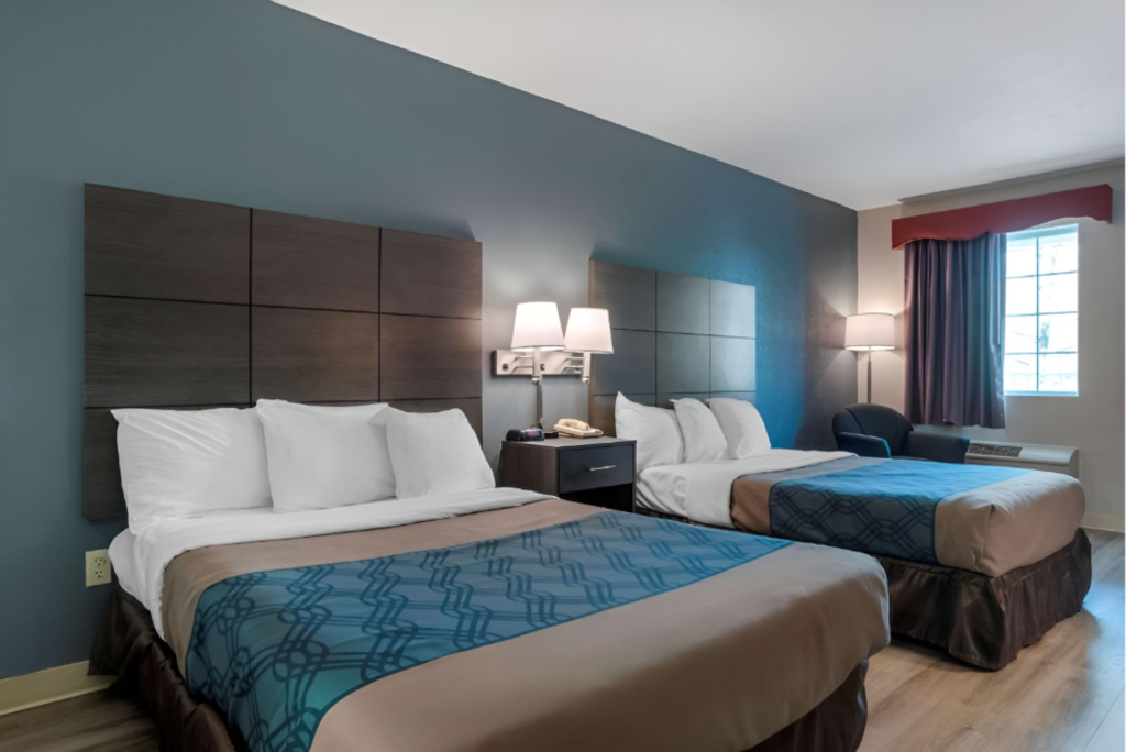 A hotel room featuring two beds against blue walls, creating a cozy and inviting atmosphere.